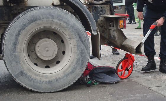 La poussette sous la roue arrière gauche du camion bétonnière.