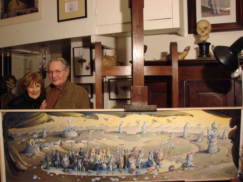 Claude Verlinde et son épouse dans l'atelier d'artiste devant la toile "La Folie mène le monde" © DR 2011 Claude Verlinde et son épouse dans l'atelier d'artiste devant la toile "La Folie mène le monde" © DR 2011